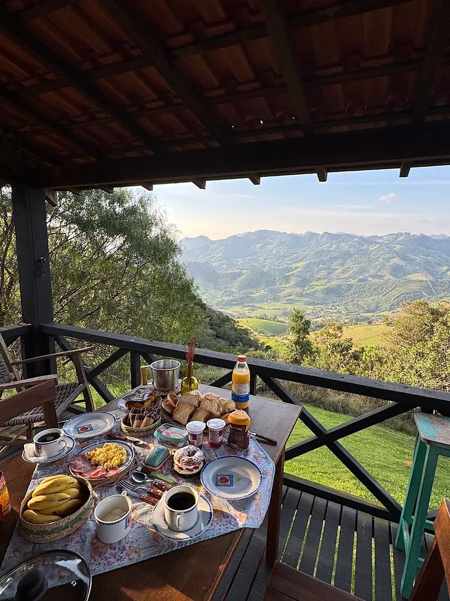 Mesa posta na varanda de madeira com vista para as montanhas ao amanhecer